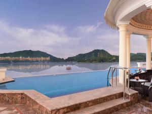 a swimming pool with a view of the water at Raffles Udaipur in Udaipur