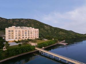 a large building next to a river with a bridge at Raffles Udaipur in Udaipur