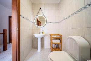 a bathroom with a sink and a toilet and a mirror at Quinta da Mina 13 in Azambuja