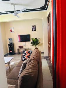 a living room with a couch and a tv at Honed homes in Mombasa
