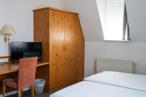 a bedroom with a desk with a computer and a bed at Hotel Grünshof in Walldorf +20 photos
