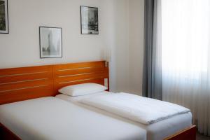two twin beds in a room with a window at Hotel Grünshof in Walldorf