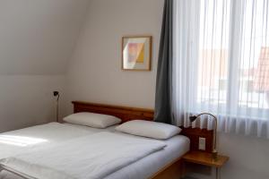 two twin beds in a room with a window at Hotel Grünshof in Walldorf