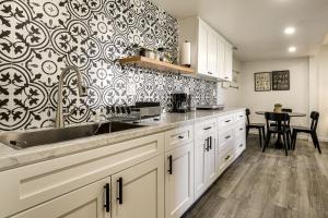 a kitchen with white cabinets and a black and white wallpaper at 2 Mi to Lake Gregory! Chic Crestline Base Camp in Crestline +20 photos