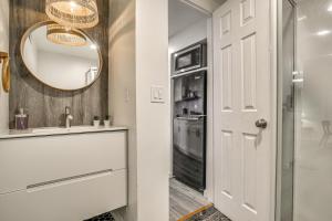 a bathroom with a sink and a mirror and a refrigerator at 2 Mi to Lake Gregory! Chic Crestline Base Camp in Crestline