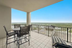 a balcony with a table and chairs and a view of the ocean at The Oasis at Orange Beach Unit 1816 in Orange Beach