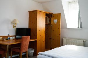 a bedroom with a desk with a computer and a bed at Hotel Grünshof in Walldorf