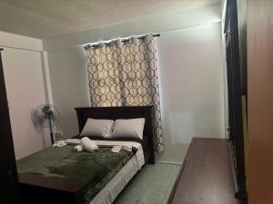 a small bedroom with a bed with a curtain and a fan at Hillside Haven in Cochrane