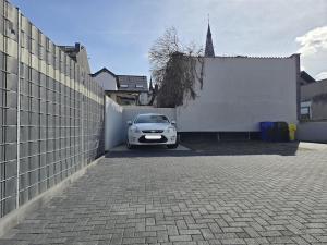 a car parked in a parking lot next to a fence at Erdgeschoss Juwel direkt hinter dem Markt I Terrasse & Parkplatz I ruhig & privat in Viersen