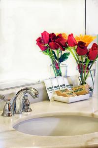 un lavabo con flores y cepillos de dientes. en Casona Plaza Hotel Centro en Puno