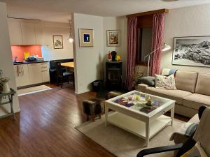 a living room with a couch and a table at Steinbock 2OG - CharmingStay in Flumserberg