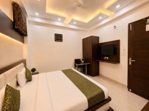 a hotel room with a bed and a television at Hotel Pleasant Taj Agra -Budget Family AC Rooms in Tājganj