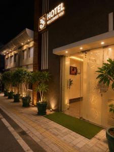 a hotel with potted plants in front of a building at Hotel Pleasant Taj Agra -Budget Family AC Rooms in Tājganj