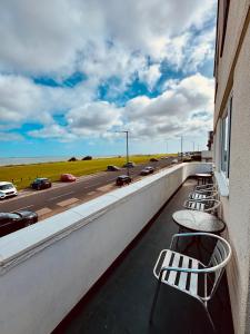 a row of chairs on a balcony with a highway at Palm Bay Residency in Cliftonville