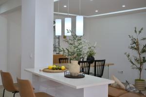 a white kitchen with a table with fruit on it at Empire Home! in Praia
