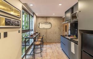a kitchen with a bar and stools in a room at Kukun Edition El Angel in Mexico City