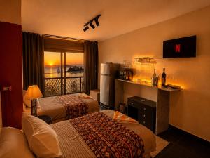 a hotel room with two beds and a refrigerator at Aswan sunrise in Aswan +26 photos