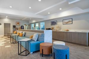 a waiting room with a blue couch and stools at Best Western Plus Pioneer Park Inn in Fairbanks
