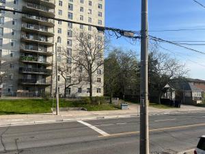 an empty city street with a tall apartment building at Stylish City Escape in Toronto