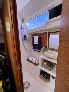 a small bathroom with a sink and a mirror at Voilier Bermuda By Villa AGADA in Gourbeyre