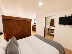 a bedroom with a bed and a flat screen tv at Loft y Parking Centro de Melipilla in Melipilla