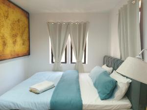a bedroom with a bed with blue sheets and a window at Y&S Residence in Olongapo