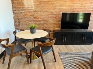 a table and chairs in a room with a tv at Brick & Bed Riverfront Lofts, T 202 in Saint Louis