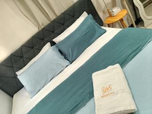 a bed with blue and white pillows on it at Y&S Residence in Olongapo