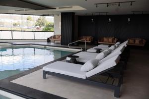 a pool with chaise lounge chairs and a swimming pool at Domun Hotel in Querétaro