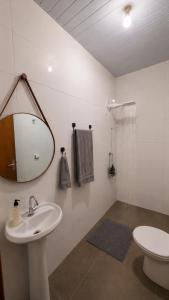 a bathroom with a sink and a toilet and a mirror at Casa de Hóspedes Jaú in Jaú