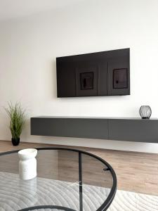 a living room with a tv on a wall at Zafiro Apartment, City Center in Kavadarci