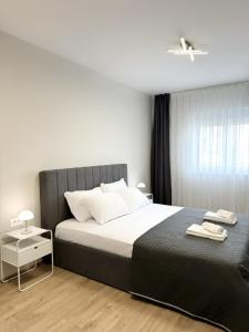 a bedroom with a large bed with a black headboard at Zafiro Apartment, City Center in Kavadarci