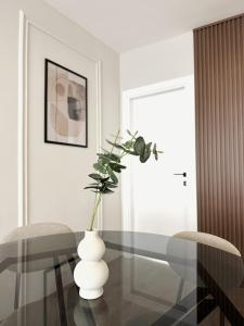 a dining room with a glass table and a vase with flowers at Zafiro Apartment, City Center in Kavadarci