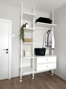 a white closet with white shelves and a dresser at Zafiro Apartment, City Center in Kavadarci +9 photos