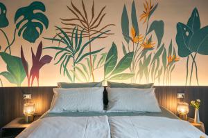 a bedroom with a bed with a mural of plants at Dimora al Glicine in Sernaglia della Battaglia