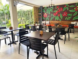 a restaurant with tables and chairs and a painting on the wall at Hotel Rimani in San Salvador