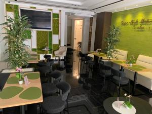 a restaurant with tables and chairs and a green wall at DonnaRosaHOME in Oliveri