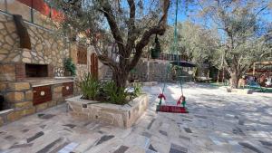 two people are sitting on a swing under a tree at Bab al-qalaa farm & chalets مزرعة وشاليهات باب القلعه in Ajloun