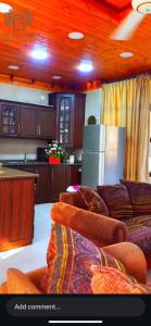 a kitchen with two couches and a kitchen with a refrigerator at Bab al-qalaa farm & chalets مزرعة وشاليهات باب القلعه in Ajloun