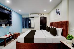 a bedroom with a large bed and a desk at Hotel O Khusi Tranquil Domicile in Bhubaneshwar