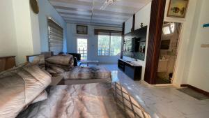 a living room with a couch and a television at Bab al-qalaa farm & chalets مزرعة وشاليهات باب القلعه in Ajloun
