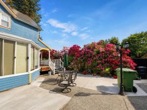 a patio with chairs and pink flowers and a house at Cozy Queen Room in Quiet Richmond Seafair Area in Richmond