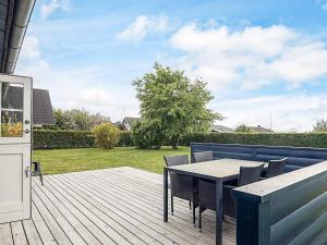 a wooden deck with a table and chairs on it at 4 person holiday home in Assens in Assens