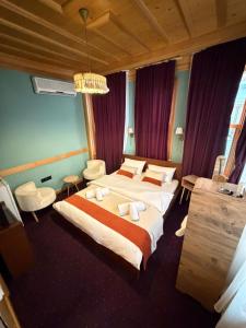 a hotel room with two beds and a chandelier at Mirello House Otel Tuzla in Tuzla