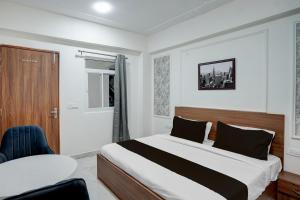a bedroom with a bed and a table and a chair at Super Townhouse Rosens hotel in Noida