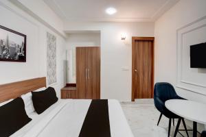 a bedroom with a bed and a table and chairs at Super Townhouse Rosens hotel in Noida