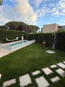 a backyard with a swimming pool and green grass at Villa Reger in Lalëz
