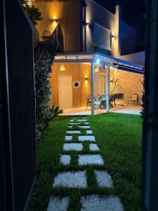 a garden with a stone walkway at night at Villa Reger in Lalëz