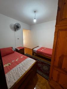 a small room with two beds and a fan at Marseilia Resort in Al Ḩammām