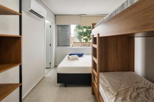 a small bedroom with a bed and a window at 8 Apartamentos em Condomínio Fechado c/portaria presencial 24 hs à Beira mar na Praia do Tombo no Guarujá in Guarujá